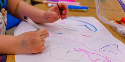 a child is drawing on a piece of paper